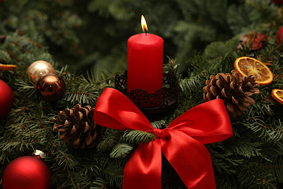Ein Adventskranz mit roter brennender Kerze (Symbolfoto)