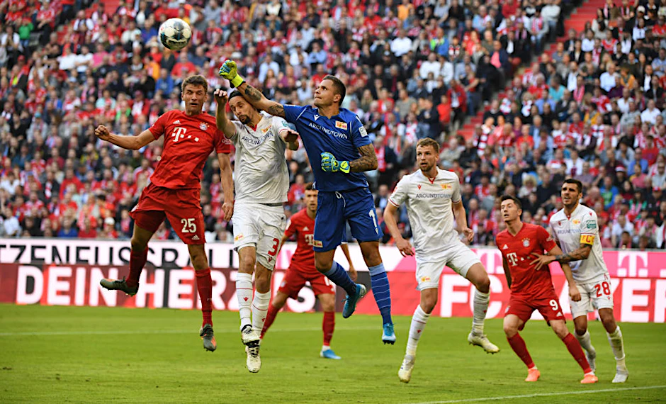 Rafal Gikiewicz klärt per Faustabwehr, bringt damit aber Benjamin Pavard (nicht im Bild) ins Spiel, der zum 1:0 für die Bayern trifft.