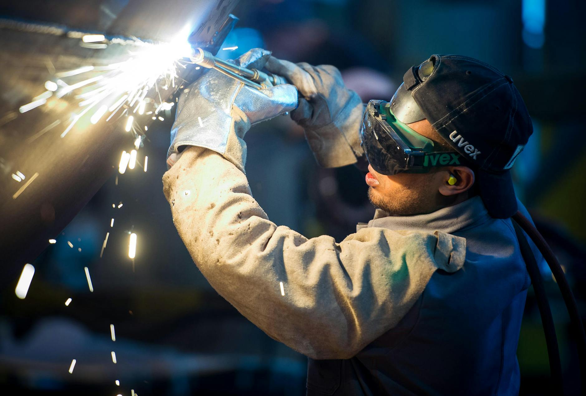 Ein Asylbewerber aus Somalia arbeitet in einer Firma an einem Stahlsegment (Symbolbild).