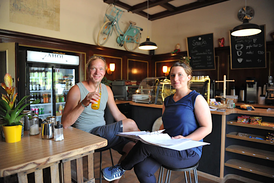 Willkommen im Café Ahoi! Tom Slotta und Amelie Kemmerzehl betreiben das Café Ahoi im ehemaligen Wartesaal erster Klasse. Mit seiner Holztäfelung und dem Parkett erinnert der Raum an das Jagdzimmer eines Gutshauses. 