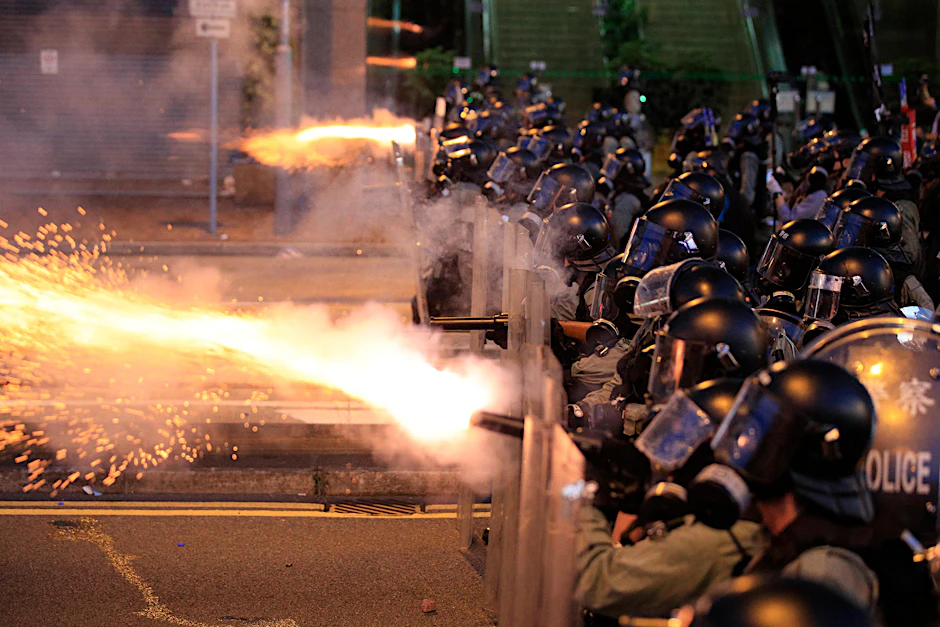 Die Polizei von Hongkong feuert Tränengas auf Demonstranten.