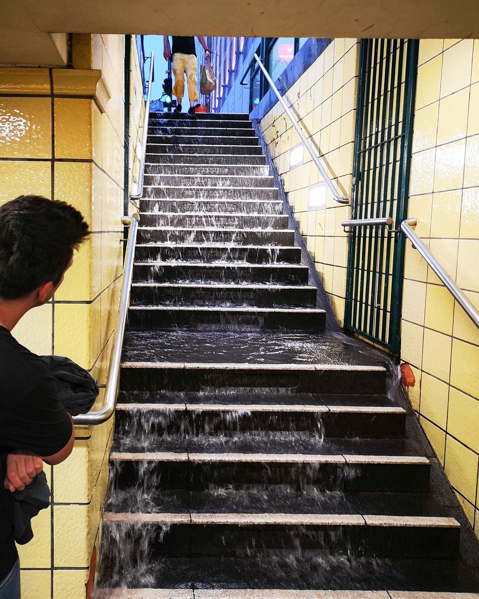 Heftige Regenfälle am Mittwochabend aufgrund eines Unwetters in Berlin: Wasser läuft die Treppen zum U-Bahnhof Friedrichstraße herunter. 