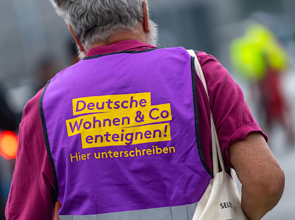 Ein Teilnehmer der Demonstration der Gewerkschaften zum Tag der Arbeit trägt eine Weste mit der Aufschrift "Deutsche Wohnen Co enteignen!"