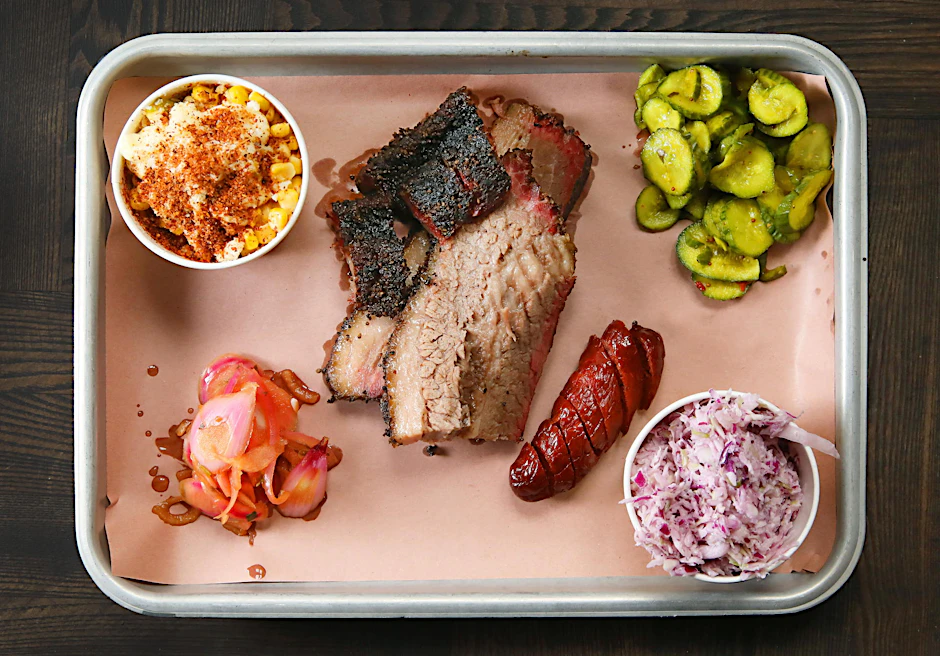 Restaurant „The Bird BBQ“ in Prenzlauer Berg: Rinderbrisket (Rinderbrust) und Chorizo mit Coleslaw, mexikanischem Streetcorn, Gurken.
