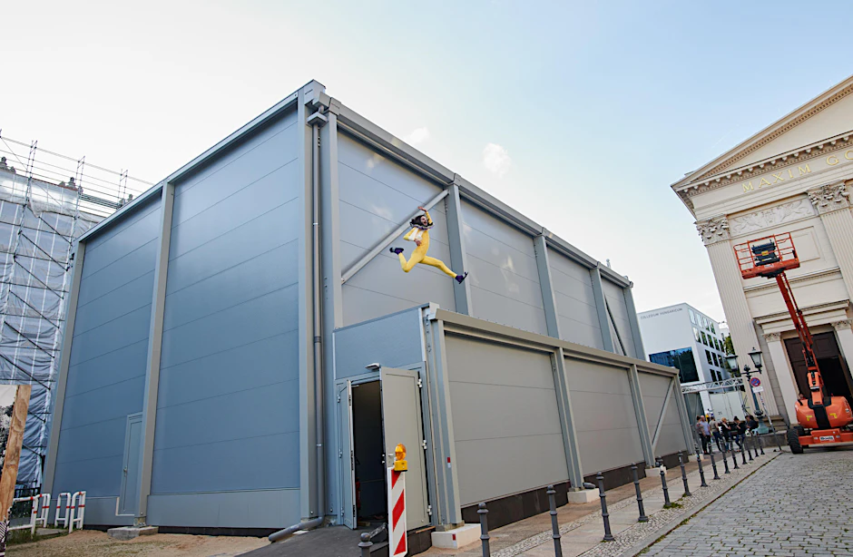 Der Schauspieler Karim Daoud springt auf dem Dach eines Containerbaus hoch.