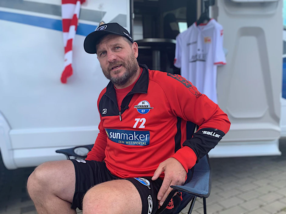 Steffen Baumgart im Campingstuhl vor dem UNVEU-Mobil.