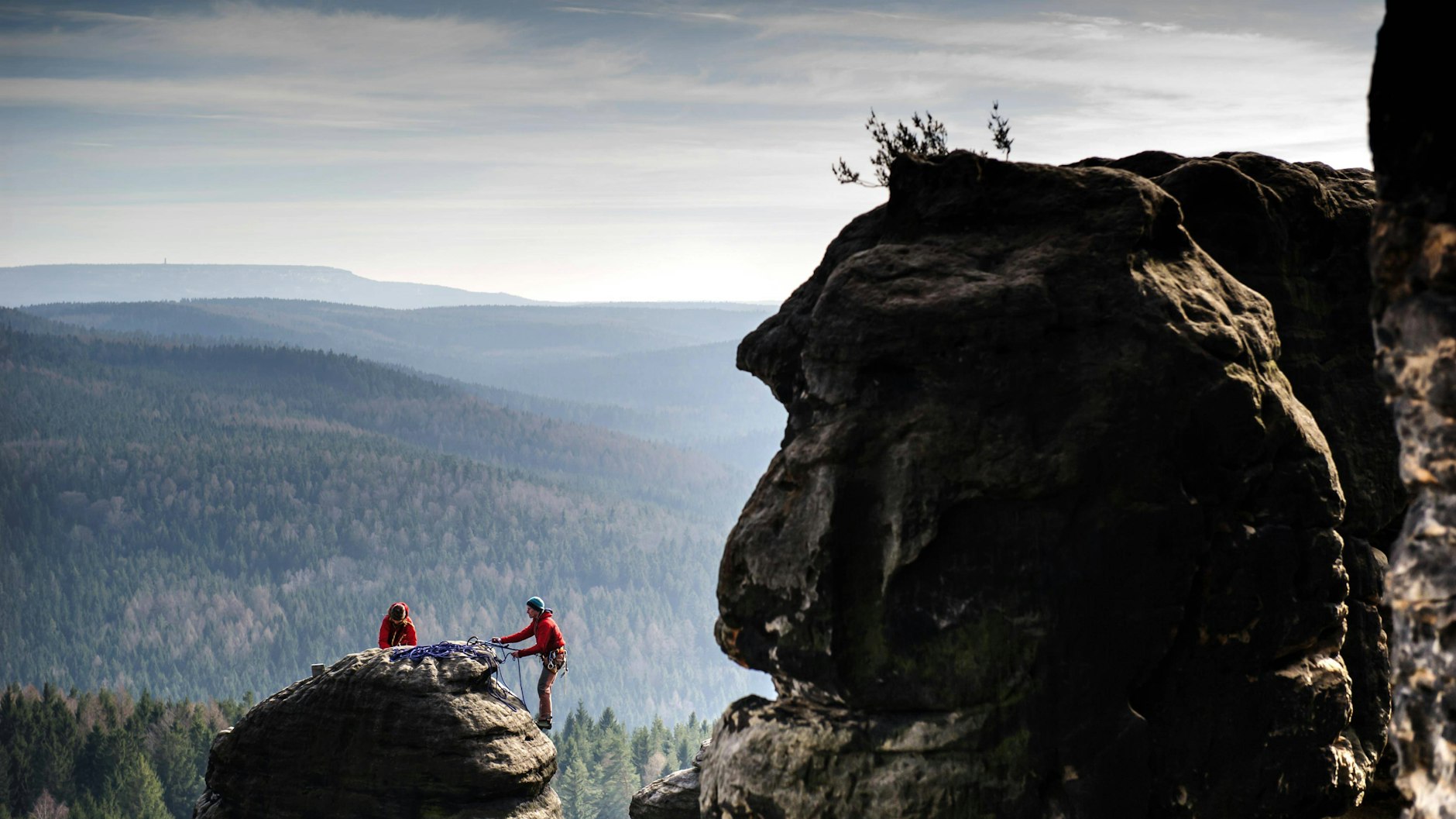 Die Region neu entdecken – ganz ohne Flugscham: Kletterer am Pfaffenstein in der  Sächsischen Schweiz.