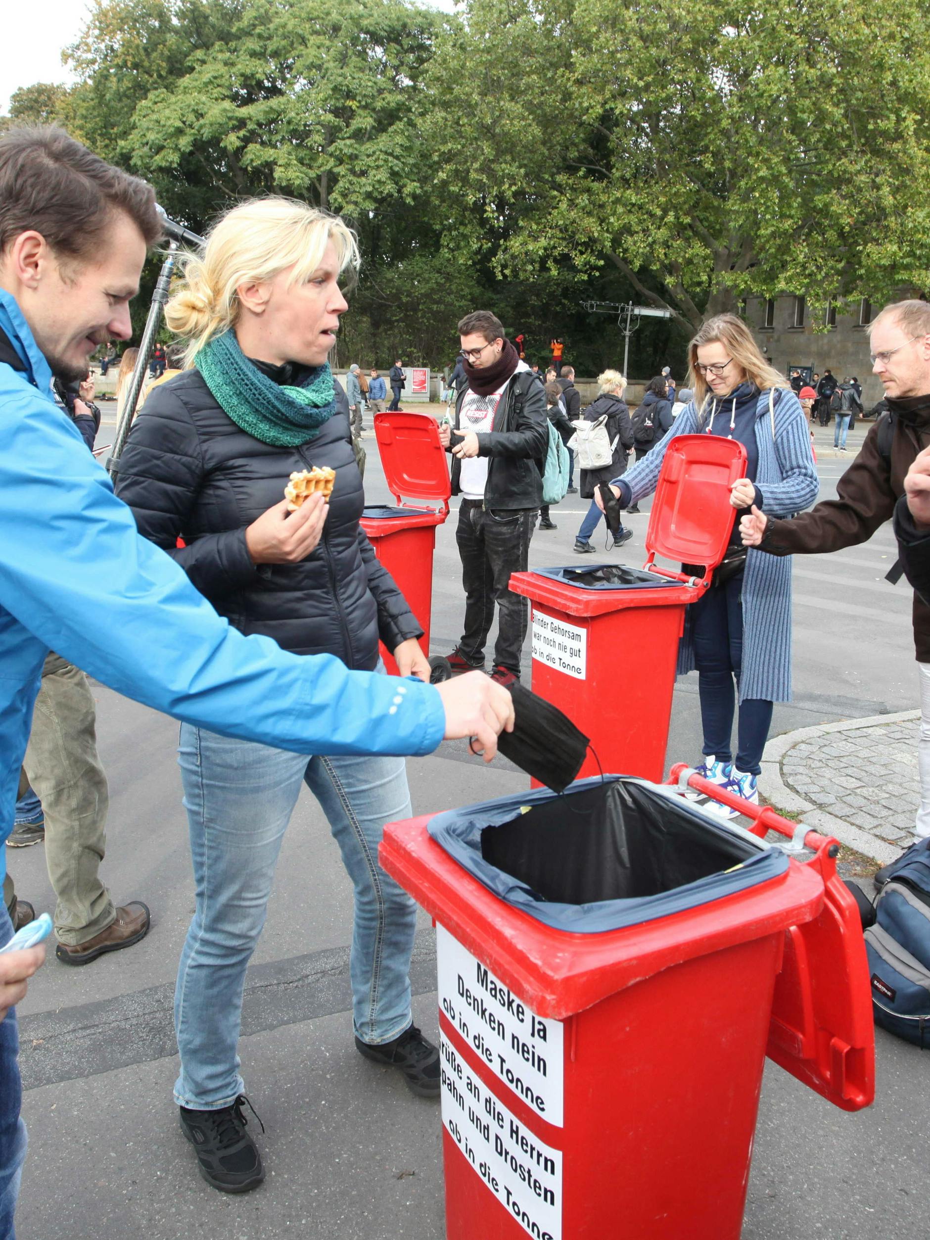 Die Masken wurden nach der Veranstaltung demonstrativ in beklebten Mülltonnen entsorgt.