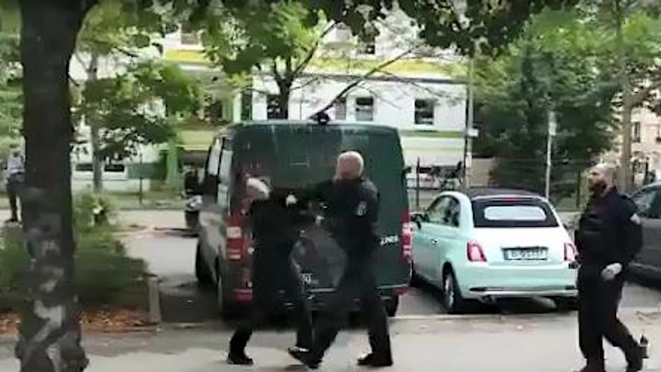 Der Polizist schlägt dem schwarz gekleideten Mann mit voller Wucht ins Gesicht. Kurz darauf wird der Mann festgenommen. <br>