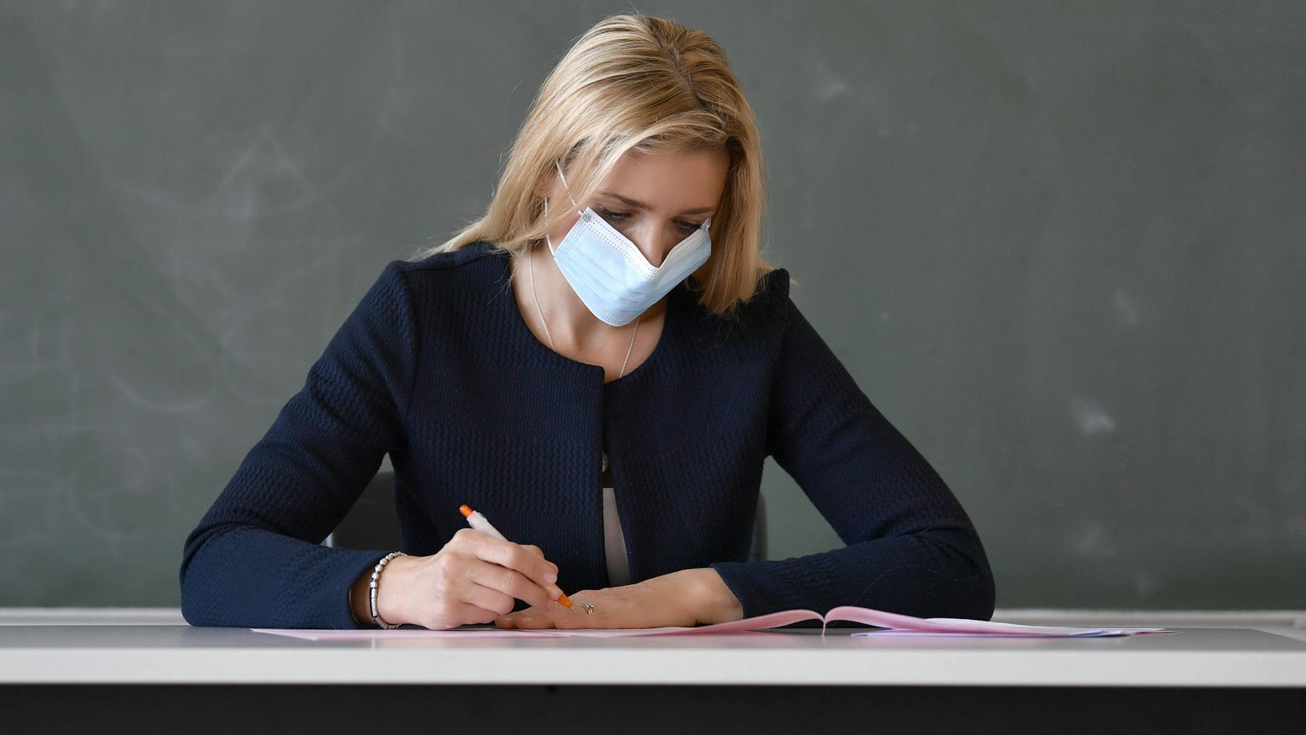Lehrerin mit Maske im Präsenzunterricht. 