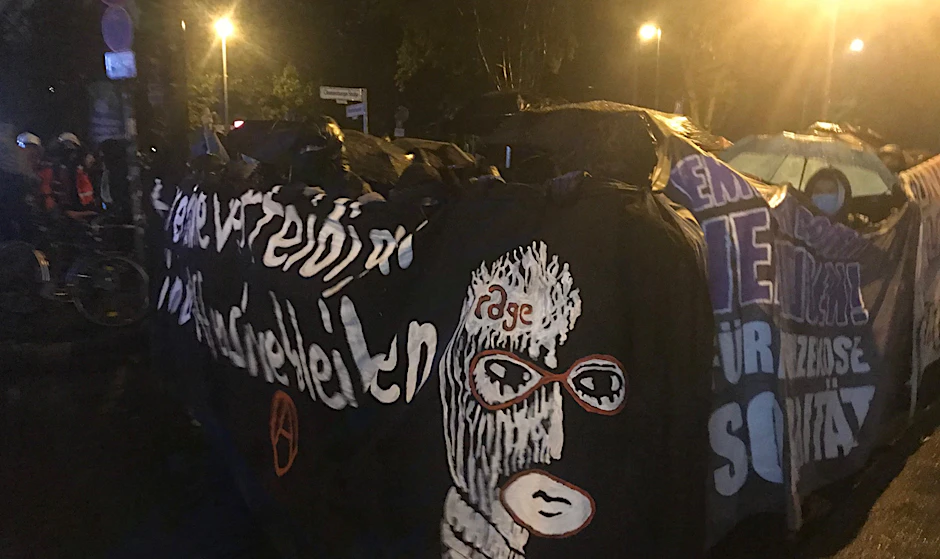 Die Demonstranten versteckten sich unter Regenschirmen und hinter Transparenten.