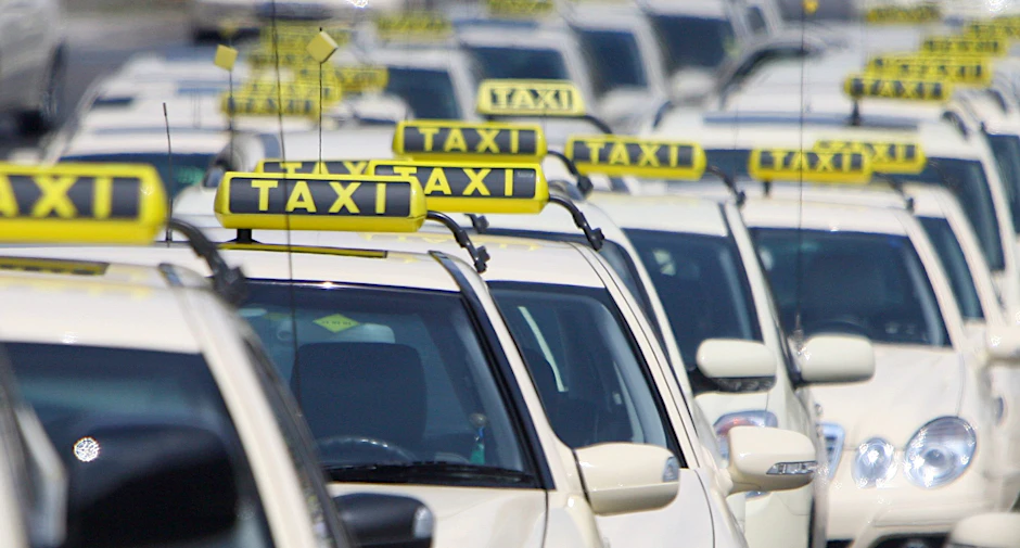 Mehrere Berliner Taxis stehen am Rande einer Demonstration. <br>