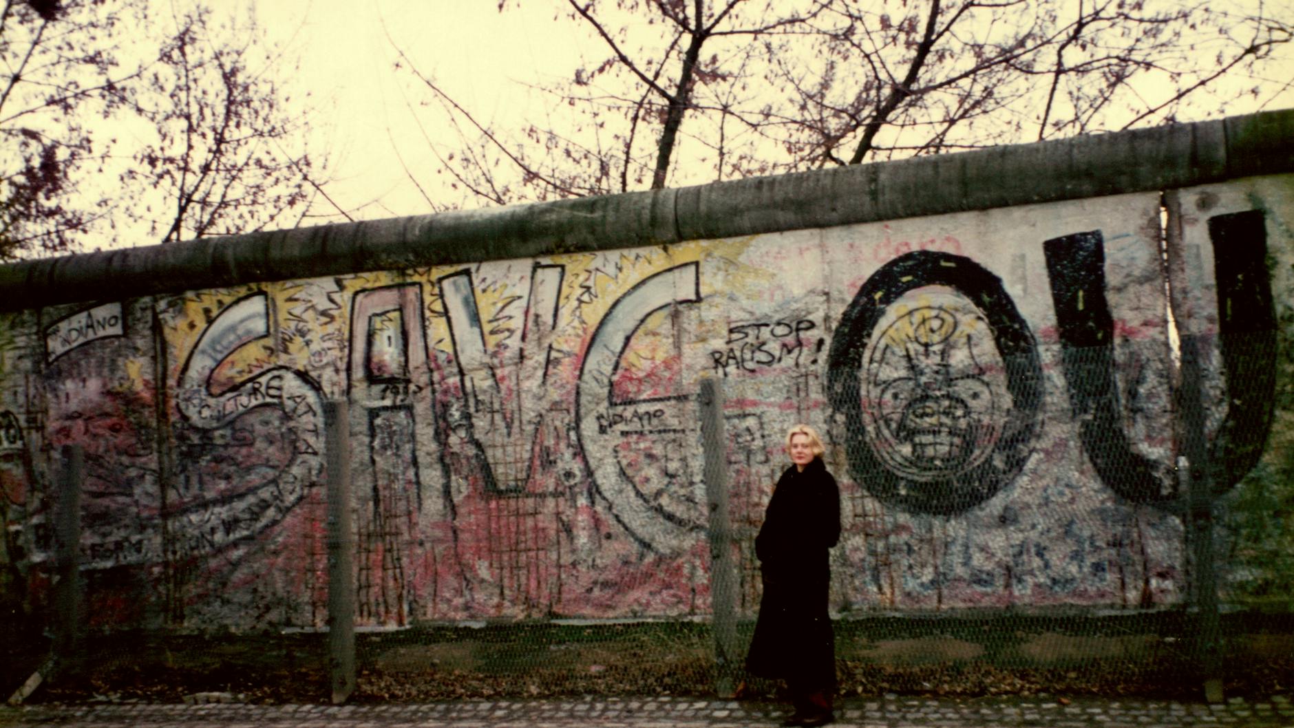 Anna Funder before a surviving remnant of the Berlin Wall in 1993.