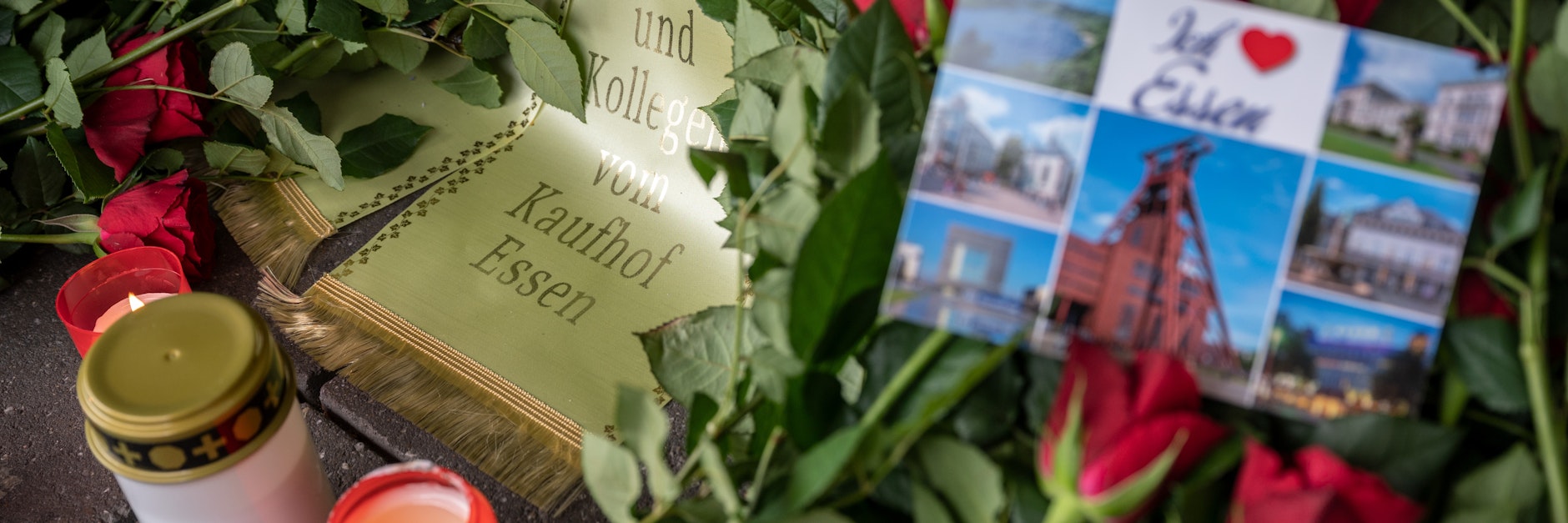Ein Blumenkranz und Kerzen sind vor der verschlossenen Tür einer Galeria Kaufhof Filiale in Essen niedergelegt worden.
