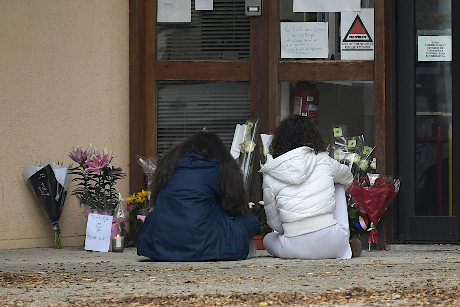 Schülerinnen trauern vor dem Schulgebäude um den ermordeten Lehrer.
