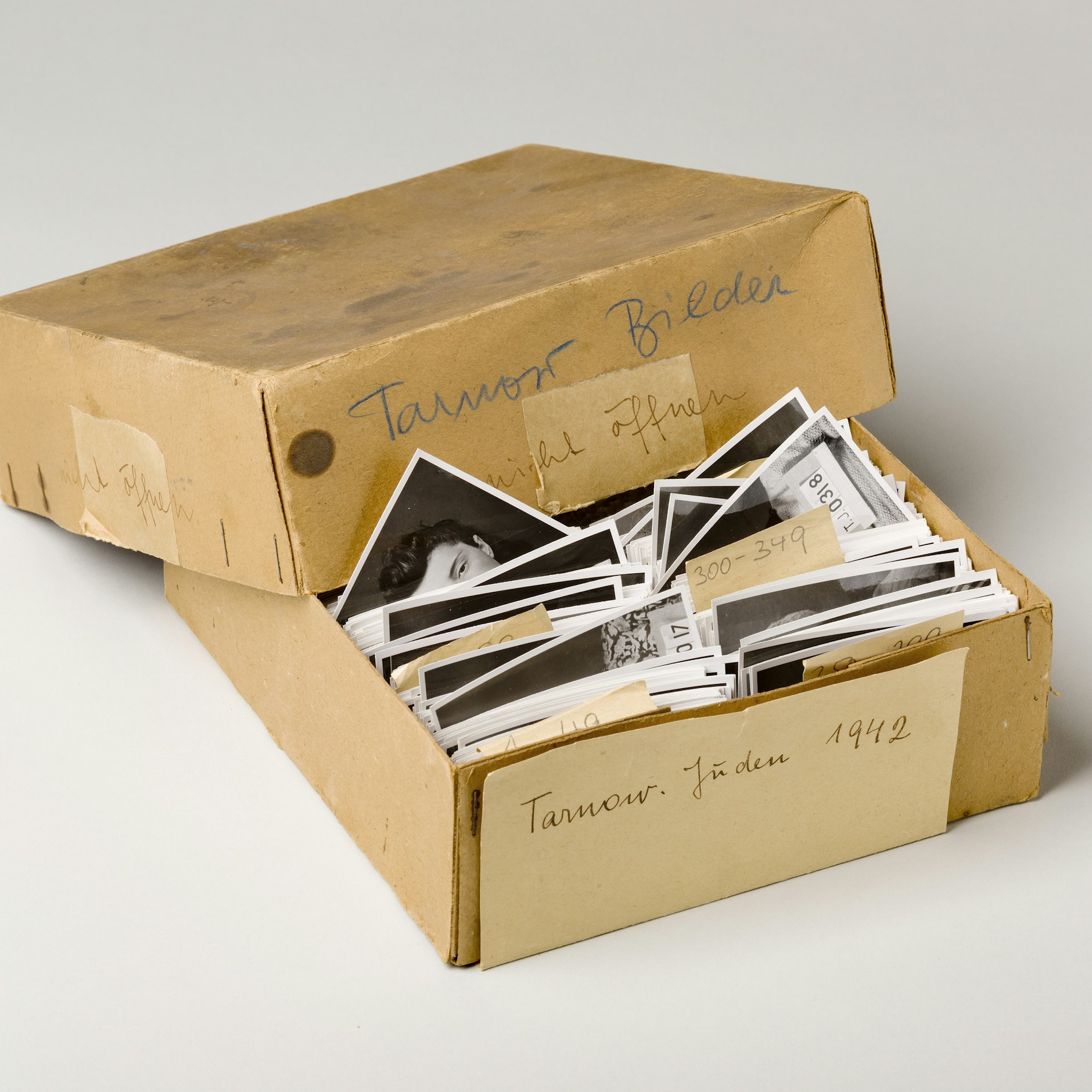 Die Schachtel mit der Aufschrift „Tarnow Juden 1942”. In dieser Schachtel fanden sich die durchnummerierten Fotos. Sie zeigen jeweils vier verschiedene Porträts von 565 Personen, in stets gleichen und damit vergleichbaren Perspektiven.