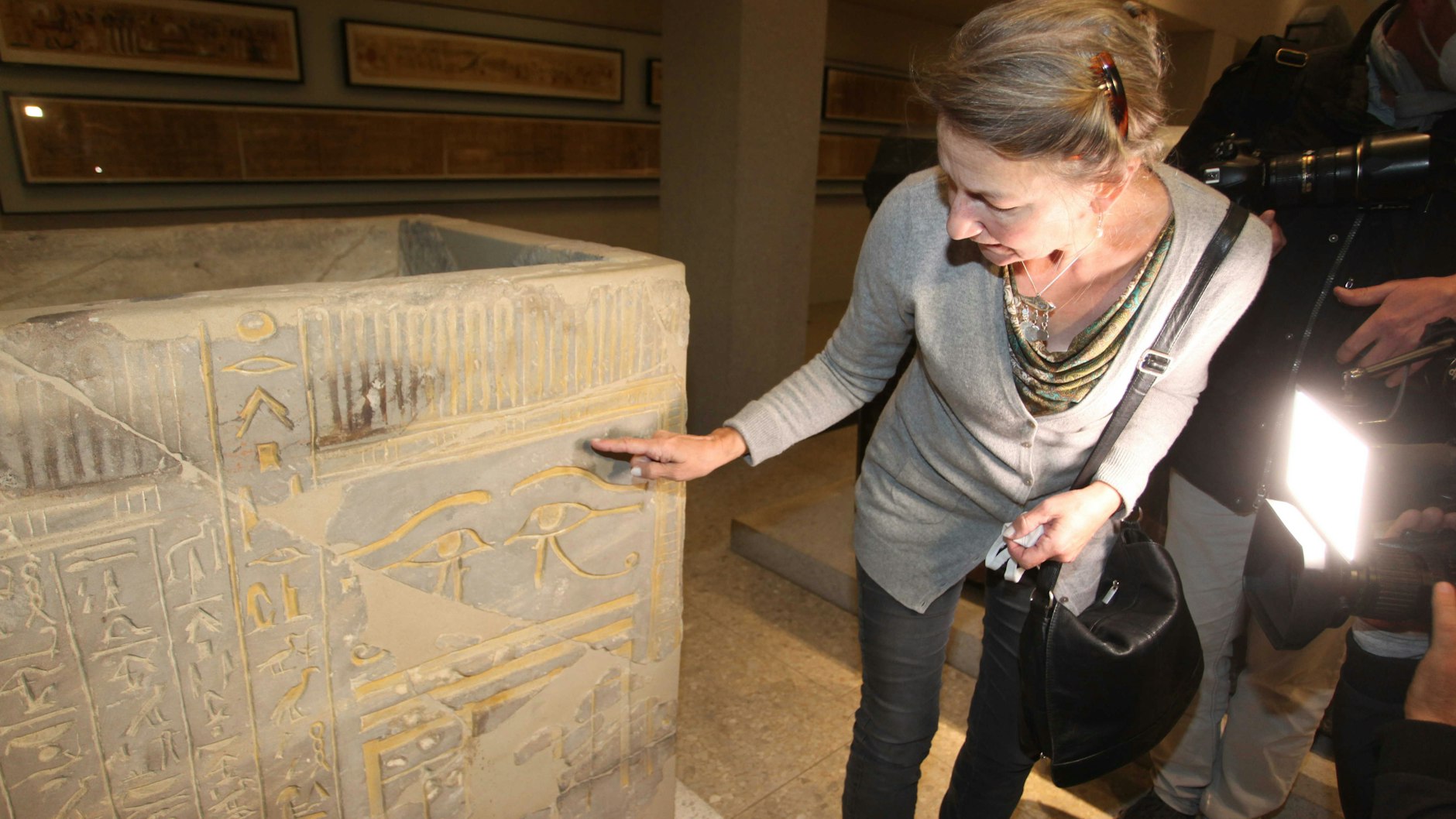 Christina Haak zeigt die Beschädigungen an einem Sarkophag.