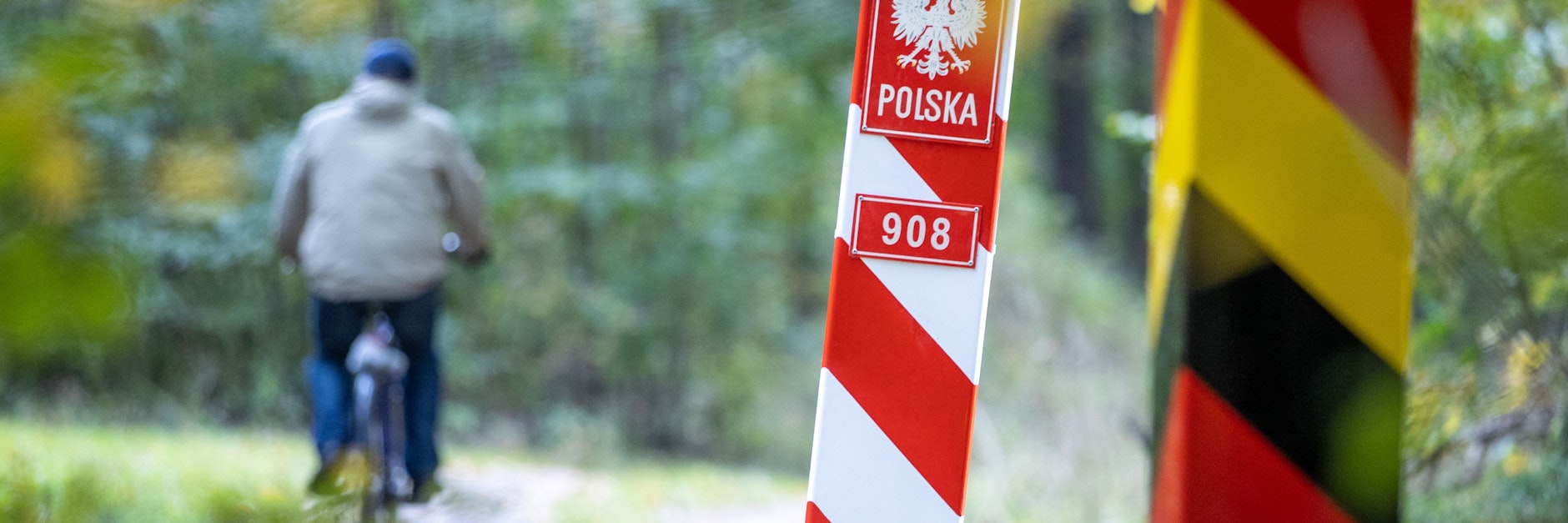 Radfahrer fährt in Mecklenburg-Vorpommern an den Grenzpfählen zwischen Deutschland und Polen vorbei.
