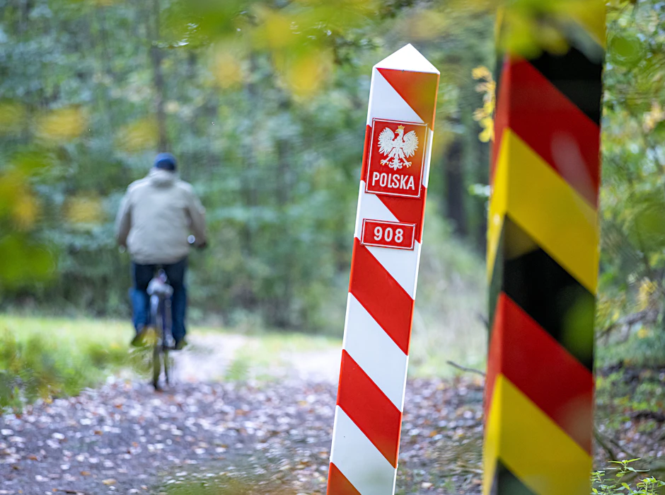 Radfahrer fährt in Mecklenburg-Vorpommern an den Grenzpfählen zwischen Deutschland und Polen vorbei.