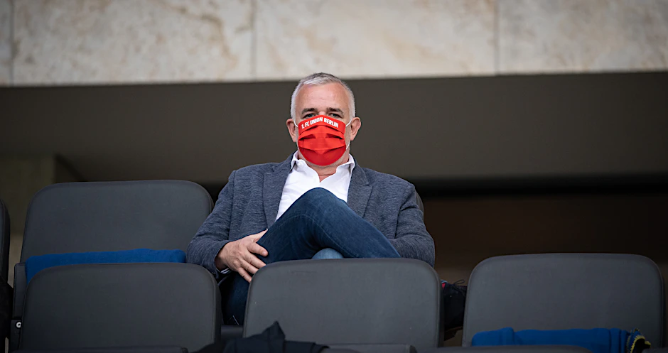Union-Präsident Dirk Zingler muss jetzt wie alle Fans der Eisernen Maske während des Spiels tragen.
