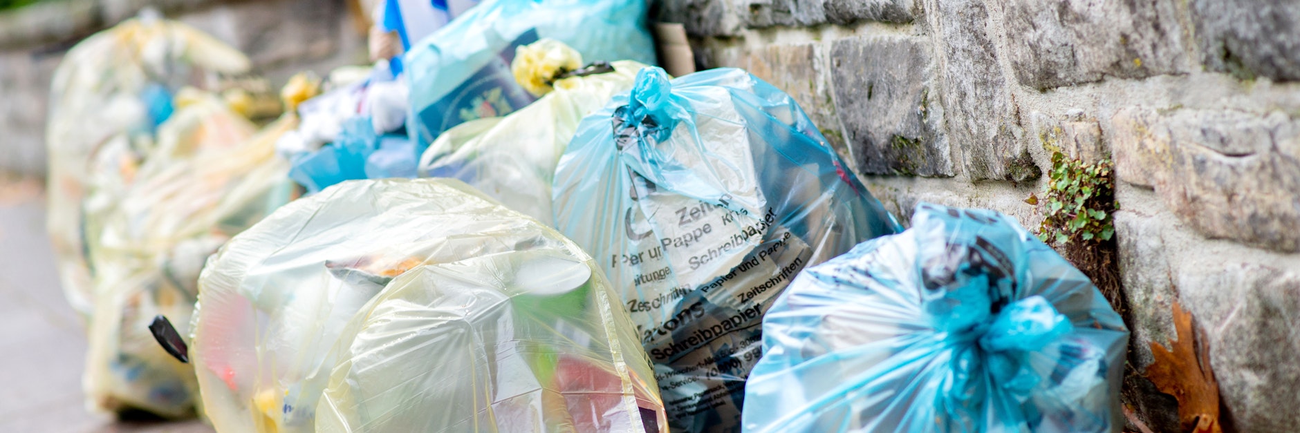 Gelbe Säcke für Verpackungsmüll und blaue Säcke für Papier liegen an einer Mauer. Der Verbrauch von Verpackungen in Deutschland nimmt weiter zu.