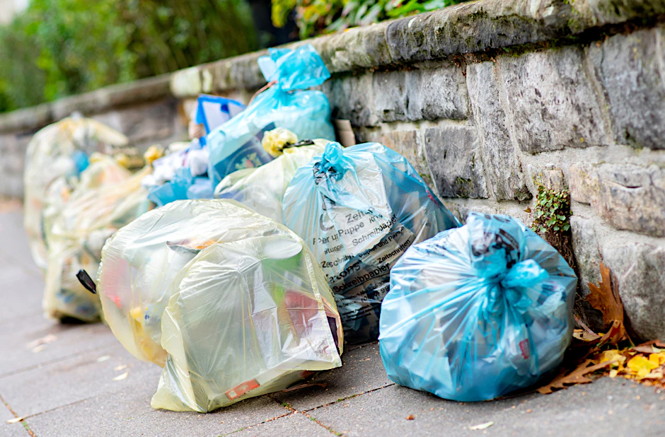 Gelbe Säcke für Verpackungsmüll und blaue Säcke für Papier liegen an einer Mauer. Der Verbrauch von Verpackungen in Deutschland nimmt weiter zu.