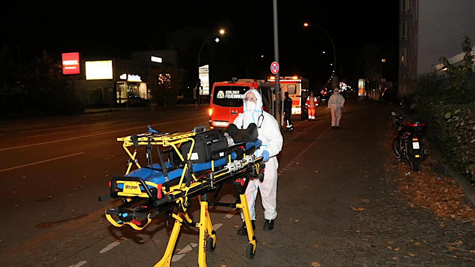 Ein Sanitäter mit einer Spezialtrage für die erkrankten Bewohner