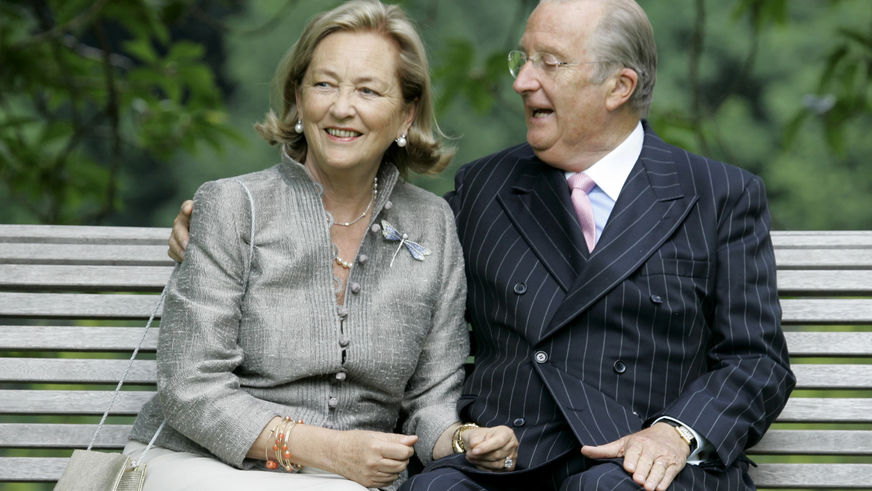 Belgiens Königin Paola und König Albert II. sitzen im Königlichen Palast auf einer Bank.