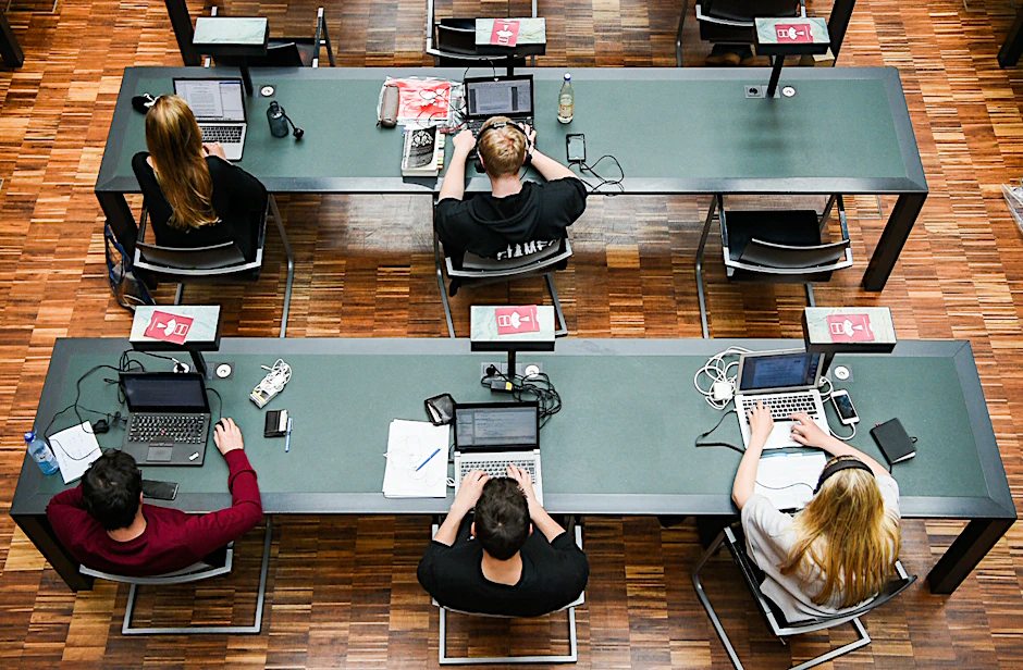 Studenten sitzen an Arbeitsplätzen im Jacob-und-Wilhelm-Grimm-Zentrum, der Großbibliothek der Humboldt-Uni.