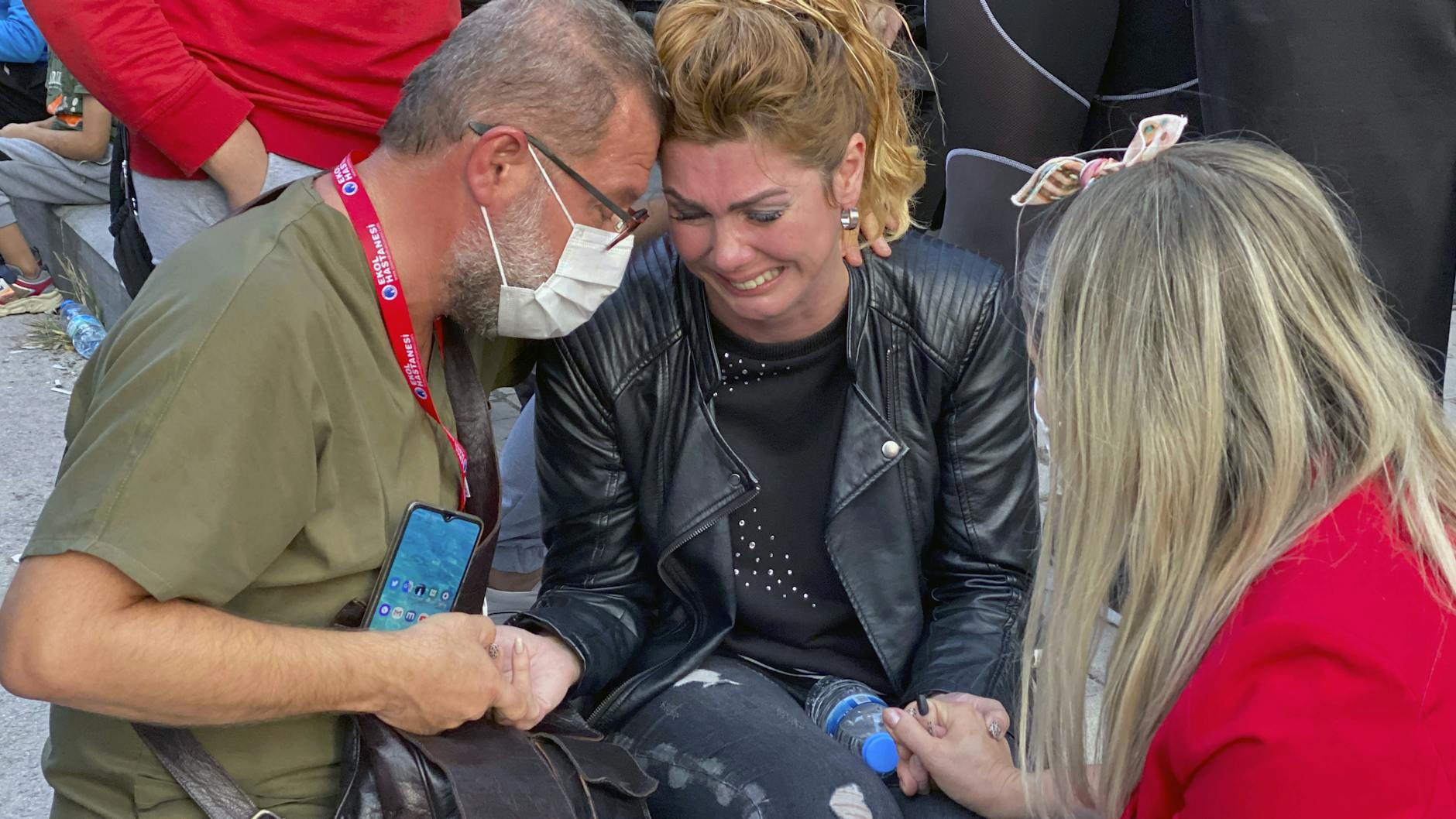 Türkei, Izmir: Eine Frau weint und wird von weiteren Menschen getröstet, während Rettungskräfte nach Überlebenden unter den Trümmern eines eingestürzten Gebäudes suchen. Das erste Beben hatte nach Angaben der nationalen türkischen Katastrophenbehörde eine Stärke von 6,6. 