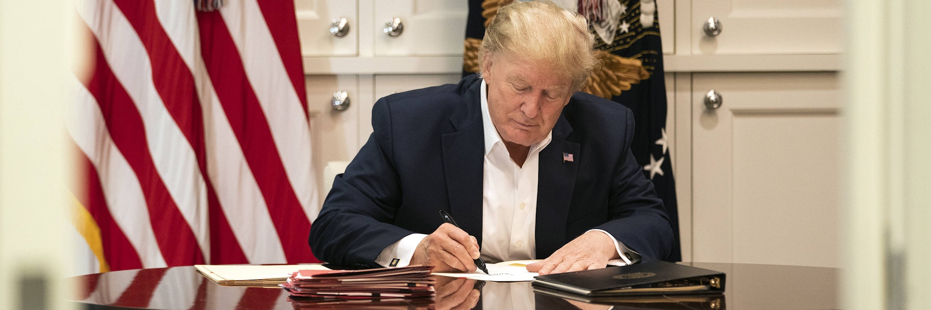 Trump angeblich bei der Aktenarbeit im Krankenhaus. Offenbar schreibt er aber nur seinen Namen auf. 