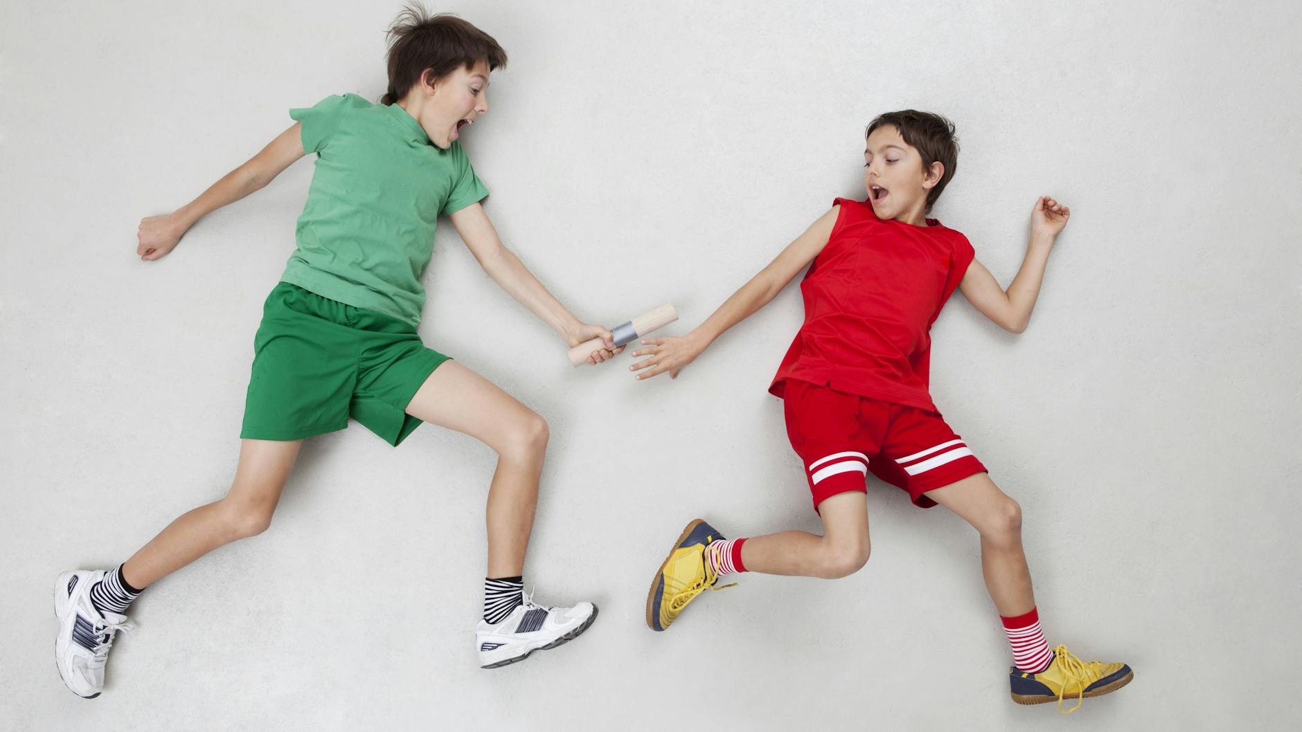 Zwei Jungen, die sich ein Staffelholz übergeben. <br><br>