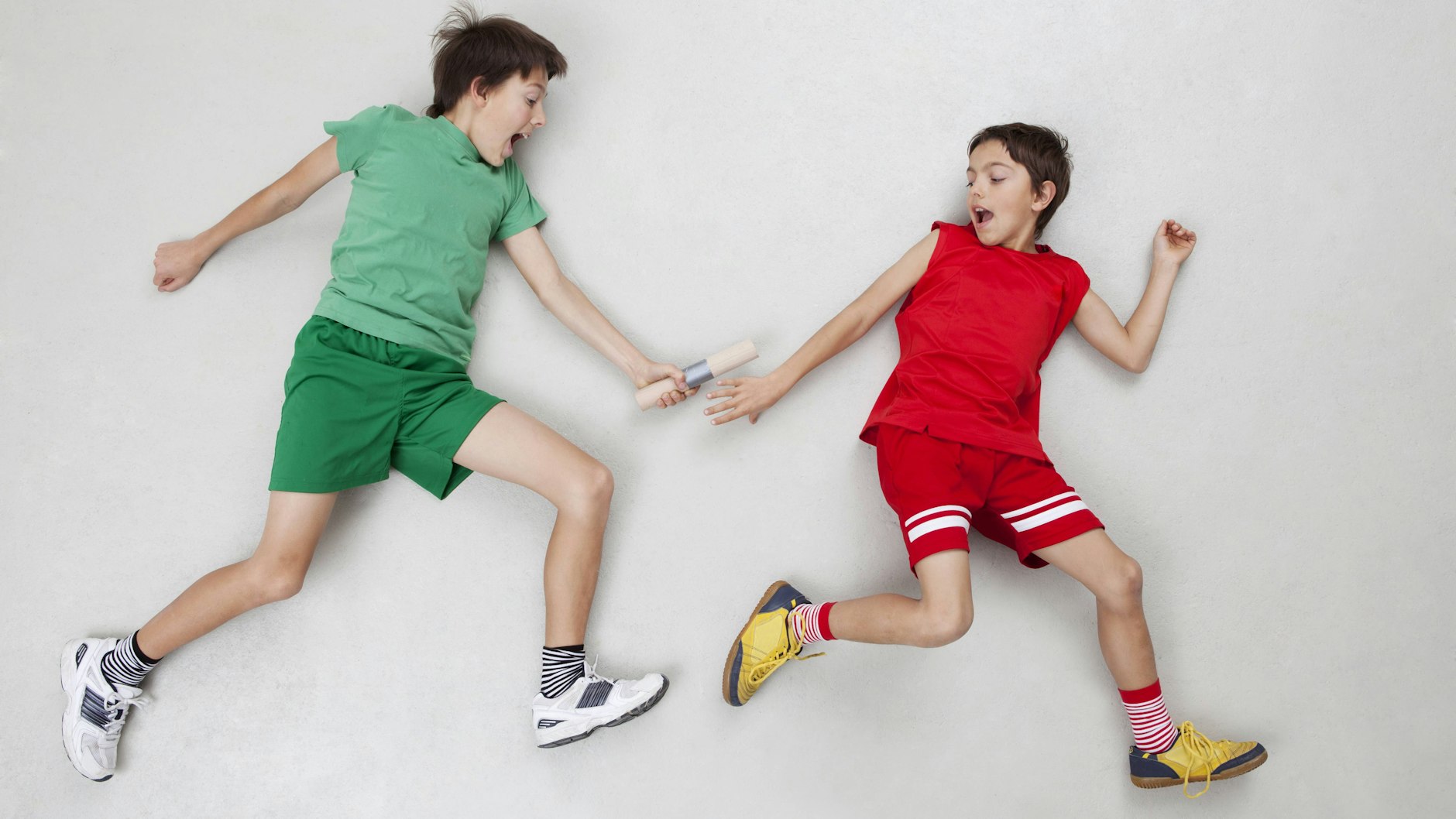 Zwei Jungen, die sich ein Staffelholz übergeben.&nbsp;<br><br>