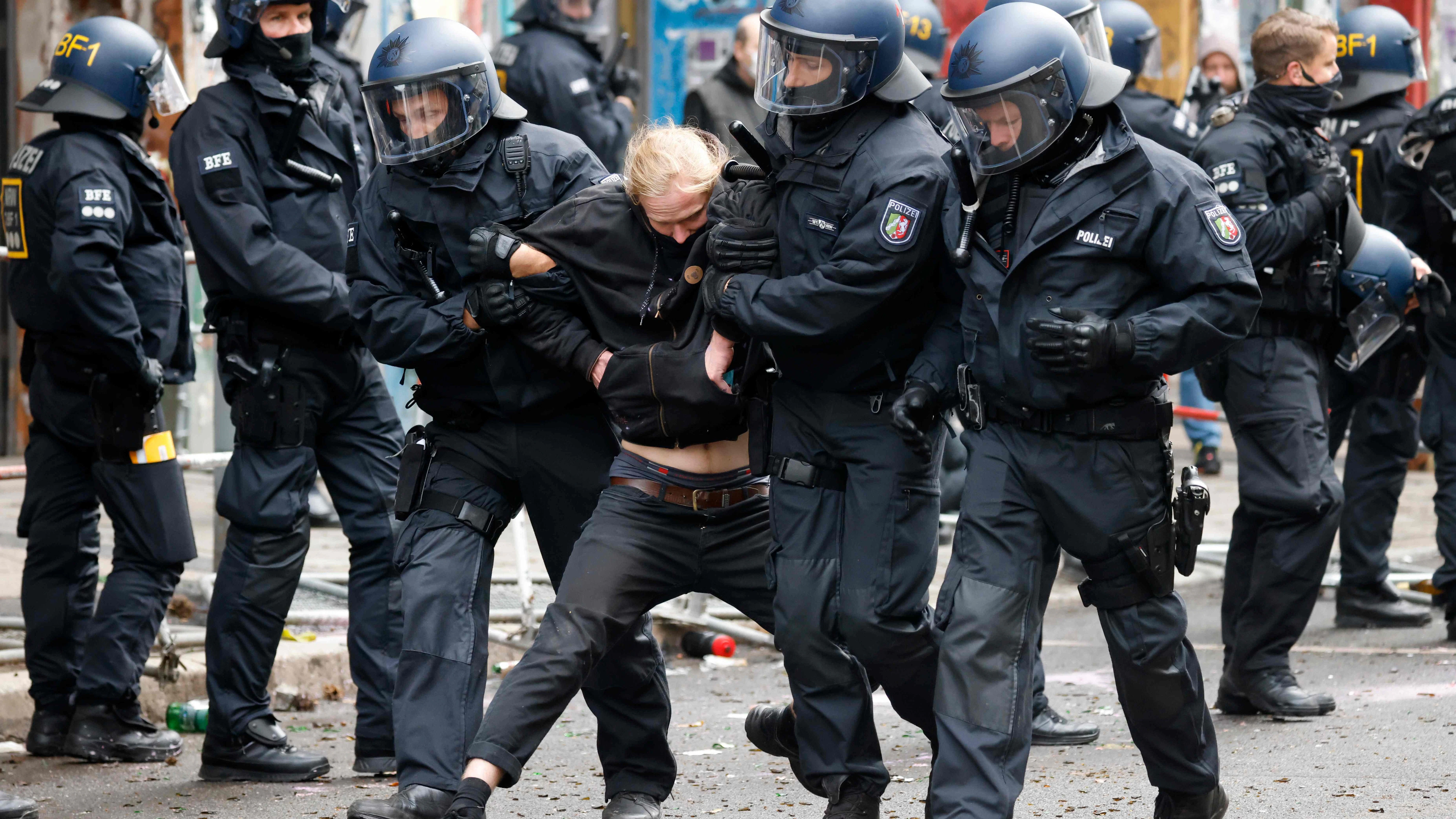 Polizisten führen einen Randalierer ab.