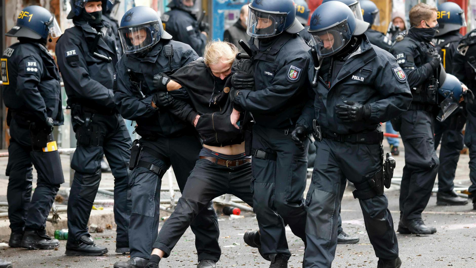 Polizisten führen einen Randalierer ab, der Widerstand geleistet hat. 