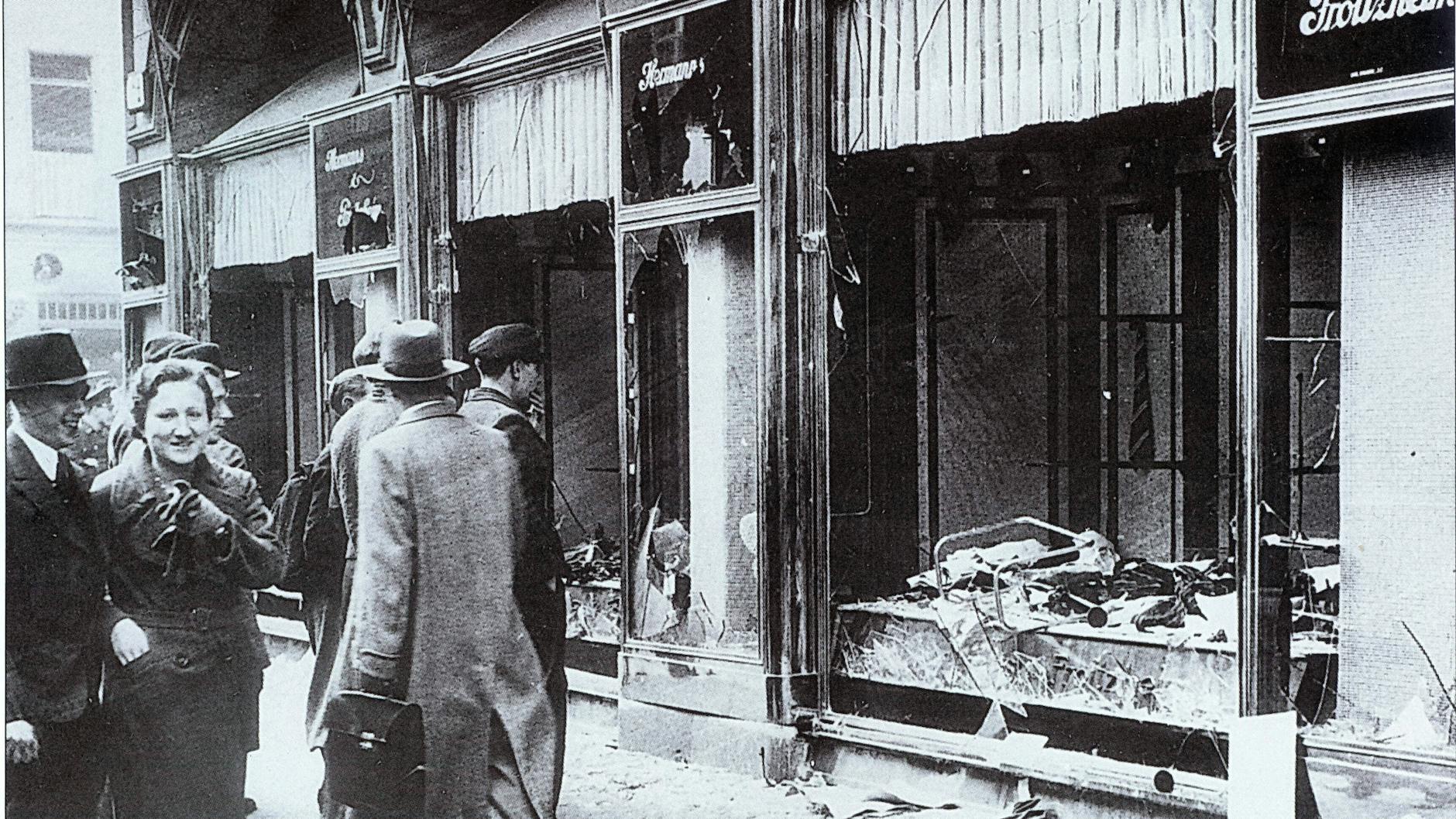Vor der Machtergreifung der Nazis ist Berlin eine Modemetropole. Der Boykott jüdischer Geschäfte beginnt kurz darauf. Das Foto zeigt die zerschlagenen Scheiben eines jüdischen Geschäfts nach den Attacken am 11. November 1938. Der Gewerbebetrieb Hermann & Frotzheim verkaufte Männermode.