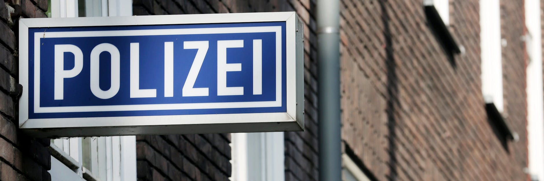 Ein Schild weist auf eine Polizeidienststelle hin. (Symbolbild)