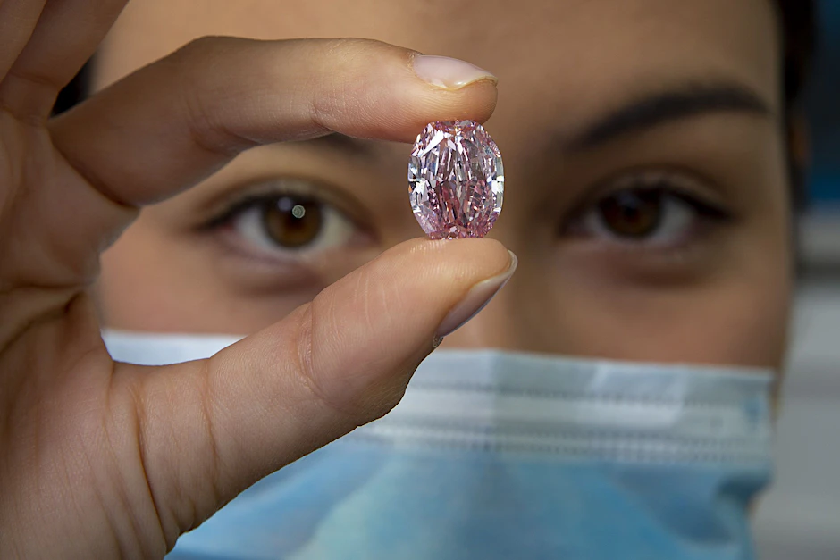 Eine Mitarbeiterin von Sotheby's hält den Diamanten "The Spirit of the Rose", einen violett-rosa Diamanten mit einem Gewicht von 14,83 Karat, während einer Vorschau bei Sotheby's.&nbsp;