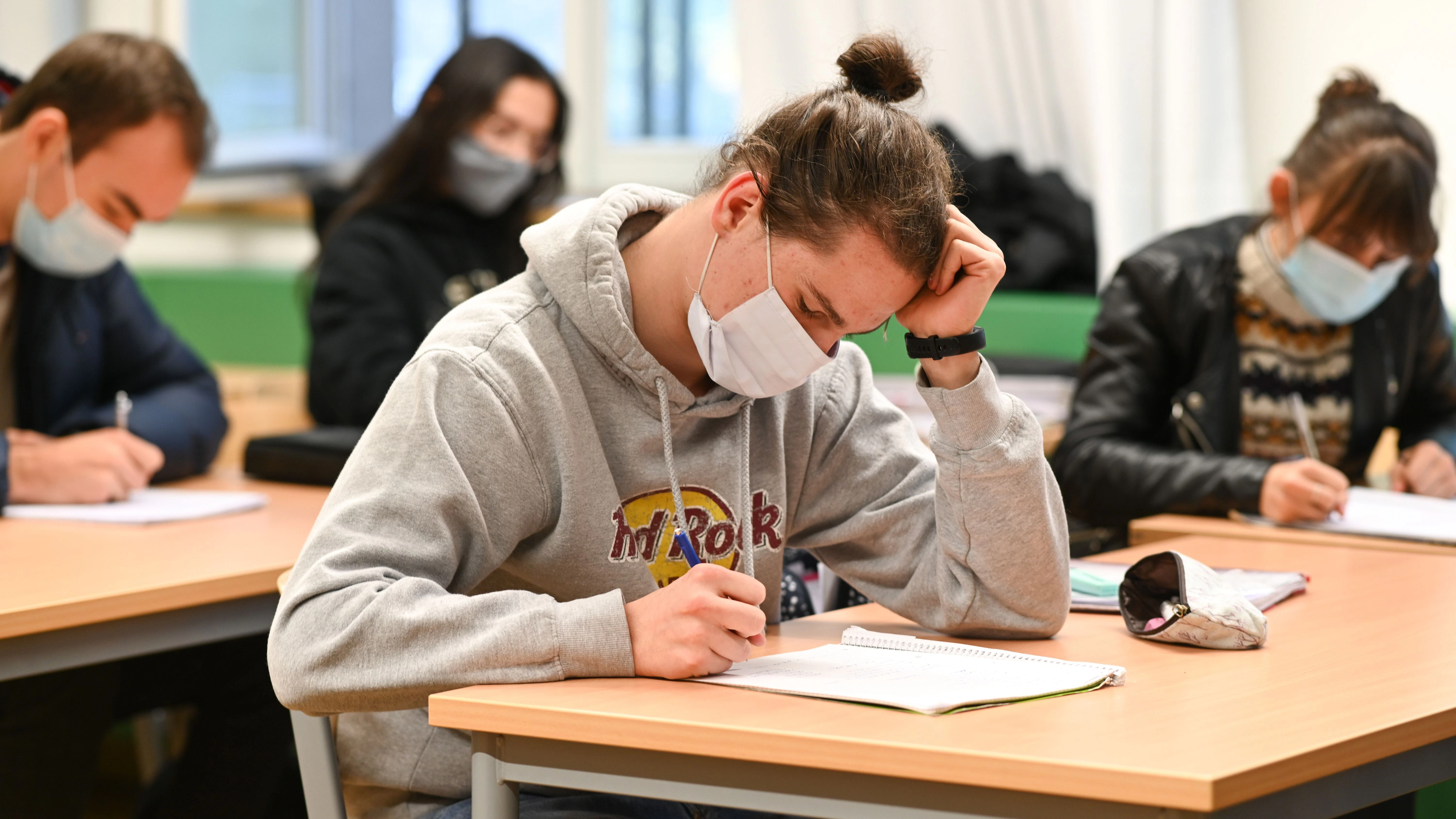 Schüler mit Mund-und-Nasen-Schutz im Unterricht – Eltern hoffen darauf, dass Schulen weiterhin geöffnet bleiben.