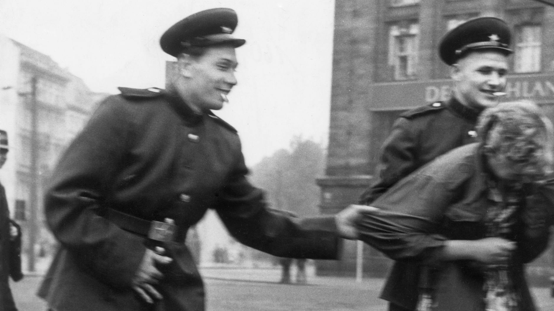 Eine Szene aus der Nachkriegszeit in der SBZ: Soldaten der Roten Armee belästigen vor der Westhalle am Hauptbahnhof in Leipzig eine Passantin. Aufnahme 1945/46.