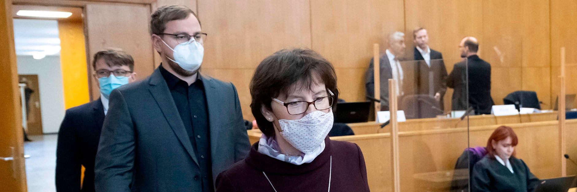 Irmgard Braun-Lübcke und ihre Söhne Jan-Hendrik und Christoph (l.) betreten den Gerichtssaal in Frankfurt. Hinten rechts (ohne Krawatte) steht der Angeklagte Stephan E., der ihren Ehemann und Vater Walter Lübcke erschossen haben soll.&nbsp;