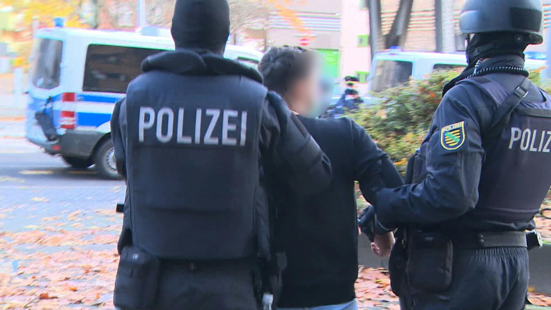 Einer der Verdächtigen wird in Neukölln von der Polizei abgeführt.