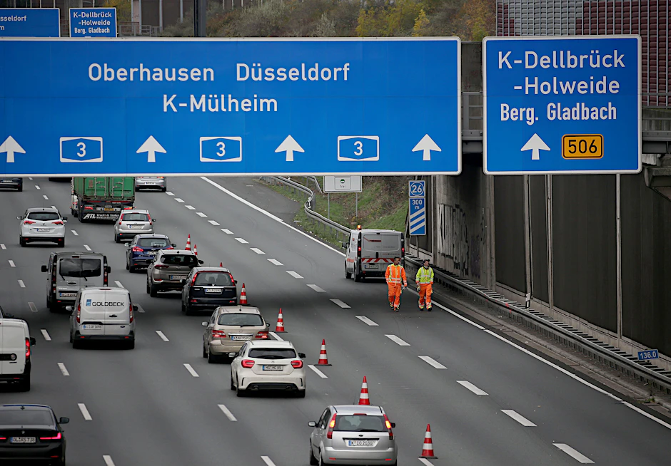 Mitarbeiter eines Verkehrssicherungsdienstes untersuchen die Stelle, an der am Freitag eine Betonplatte auf das Auto einer 66-jährigen Kölnerin gestürzt war.&nbsp;