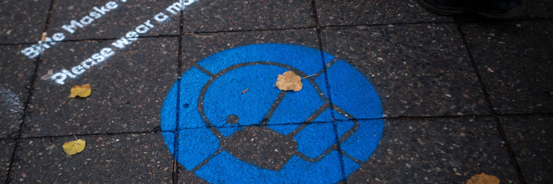 Auf der Bölschestraße, einer großen Einkaufsstraße, wird mit Hinweisen auf dem Pflaster auf die Maskenpflicht aufmerksam gemacht.&nbsp;