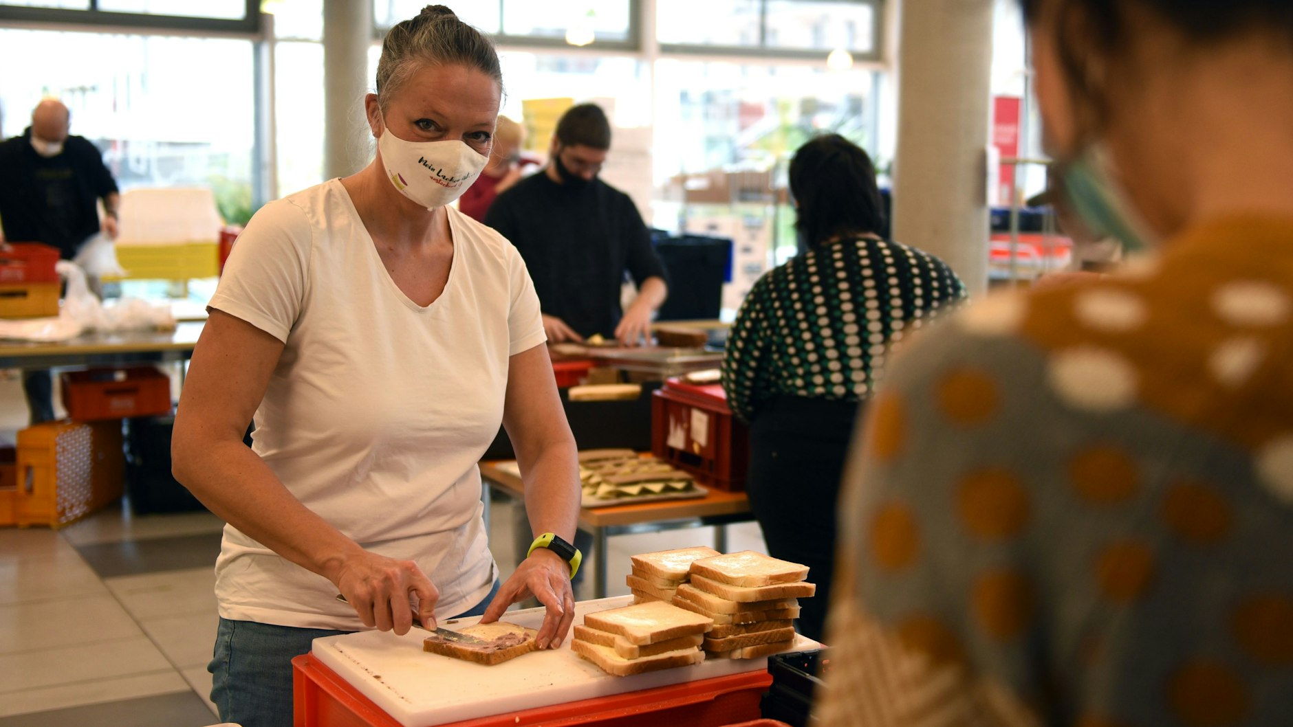 Nicole-Kristina David-Ulbrich schmiert mit anderen Freiwilligen Brote für Bedürftige. Der Bedarf wächst, weil Suppenküchen schließen.