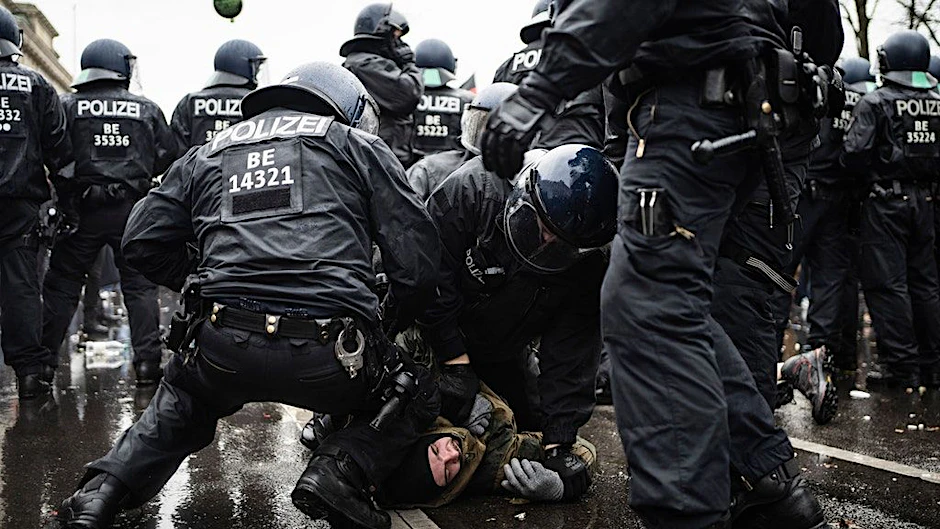 Polizisten nehmen vor dem Brandenburger Tor einen Demonstranten fest.<br>