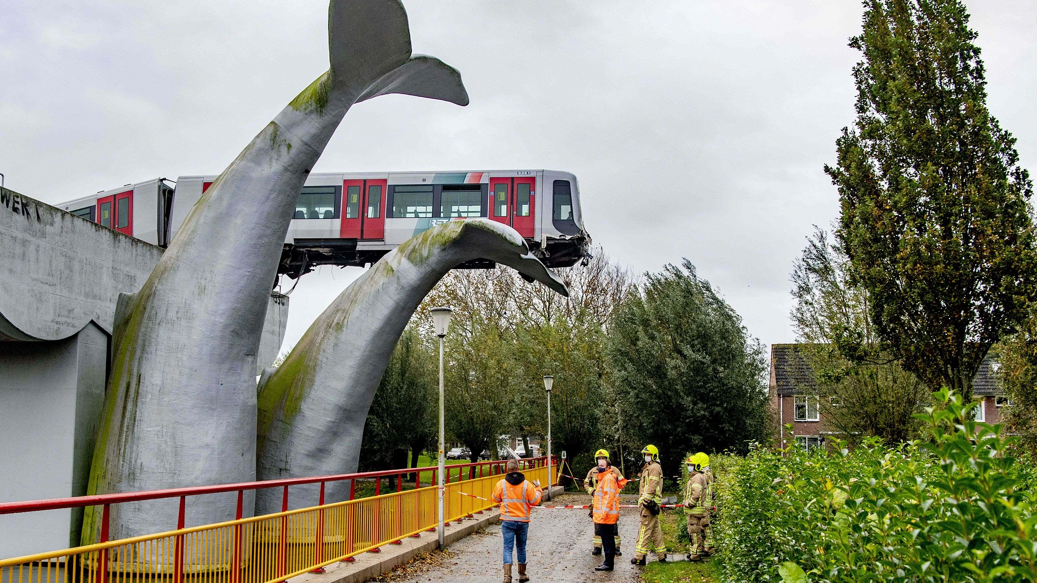 Das Kunstwerk besteht aus zwei aus Kunststoff gebauten Fluken, die direkt beim Metro-Bahnhof De Akkers etwa zehn Meter hoch aus dem Wasser ragen.