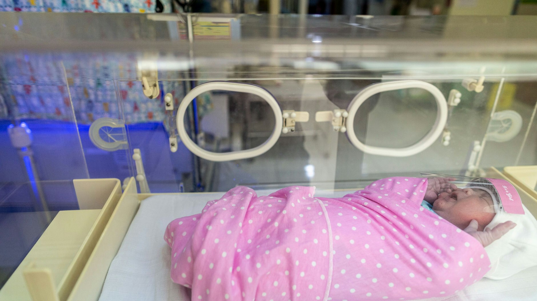 Ein Baby liegt im indonesischen „Tambak Mothers and Child“-Krankenhaus mit einer kleinen Schutzmaske aus Plastik.