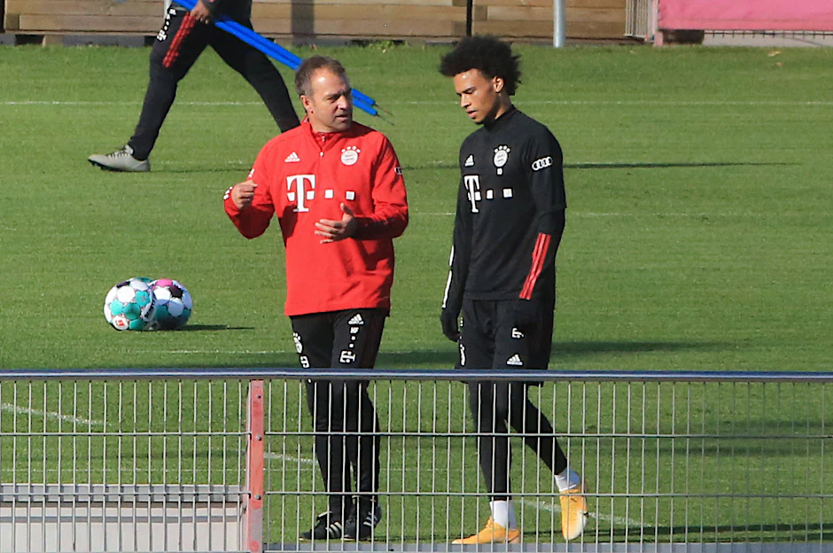 Bayerns Coach Hansi Flick muntert Nationalspieler Leroy Sane beim Training auf.