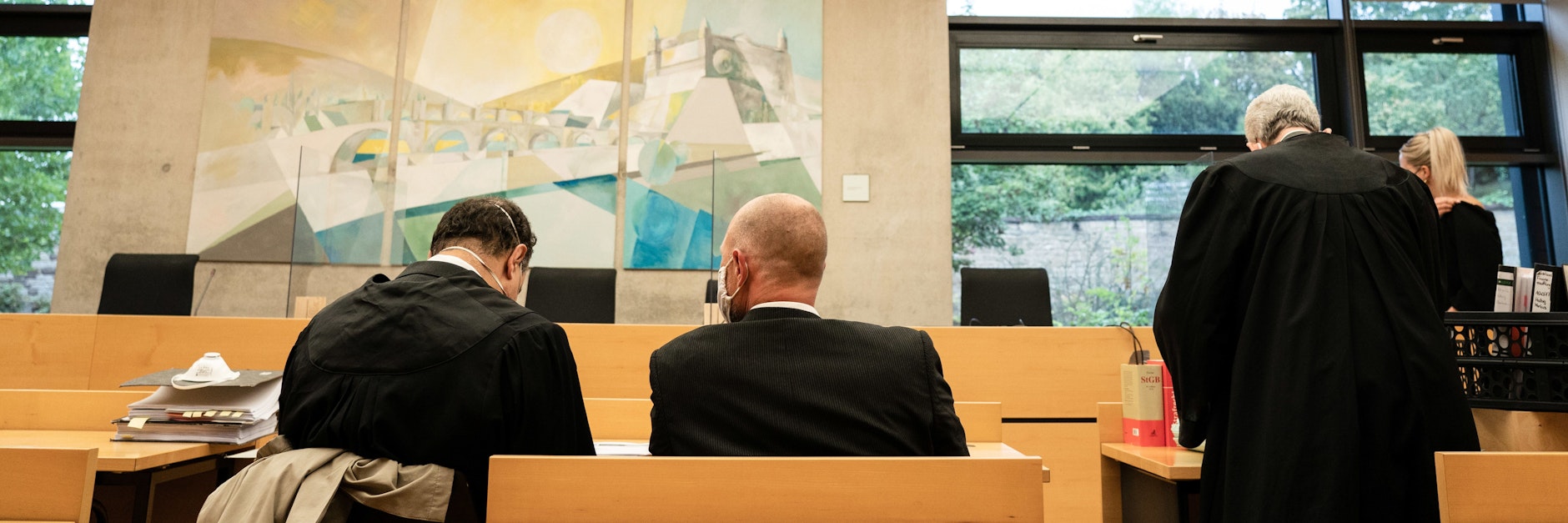 Der wegen Betruges und Drogenbesitzes angeklagte Polizist (Mi.) zusammen mit seinen Anwälten beim Prozessbeginn am 30. September.